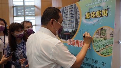 侯友宜市長在社區觀摩時，得獎的社區管委會熱情邀請市長替社區宣傳立牌簽上姓名