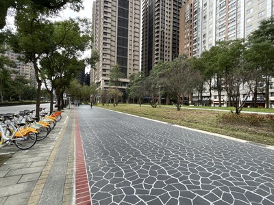 圖說：三峽北大特區「草地公園」改善周遭人行道積水問題，並採用噴花地坪設計，與周邊公車站牌及YouBike微笑單車租借站銜接，為民眾提供舒適的步行環境。
