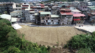 養工處採取兩階段搶修復建作業，拆除影響邊坡違建及危樓、鋪設防護網，以及採用噴射混凝土樁與排樁貫入岩層穩定邊坡等工法，完成搶災工程，提供住戶安全進出的通行環境。圖為施工後。