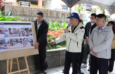 養工處長鄭立輝(右二)說明蘆洲國小周邊人行道及通學環境改善成果，新北市政府工務局長馮兆麟(右一)也在場聽取簡報。