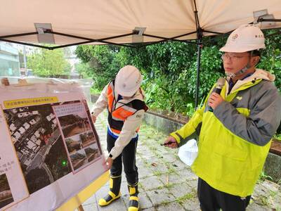 養工處長鄭立輝(右一)簡報說明汐止區康寧街與福德一路口的邊坡崩塌搶修工程進度。