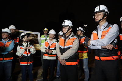 工務局長馮兆麟(右二)與副局長林炳勲(右一)等一行人，視察拆除大漢橋機慢車專用道分隔島的夜間施工現況。